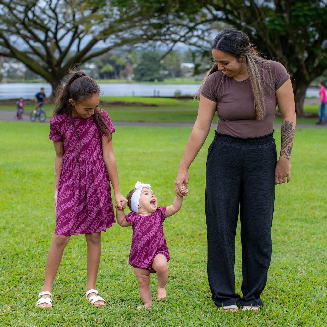 Woman and two children wearing a pakalana strands dress and flutter romper walking together in a park