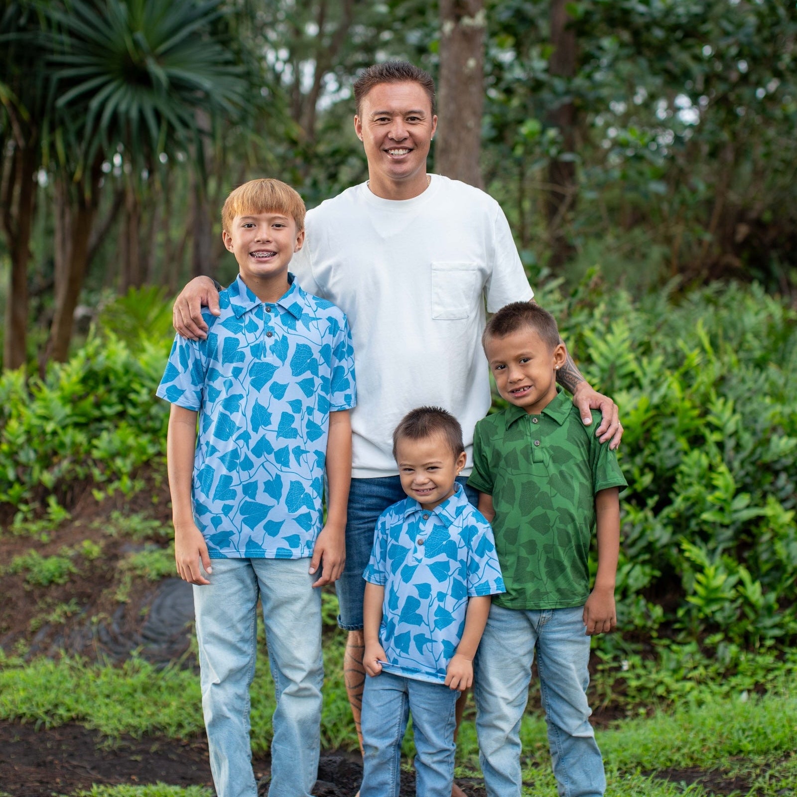 Man with three sons standing together in a forested area