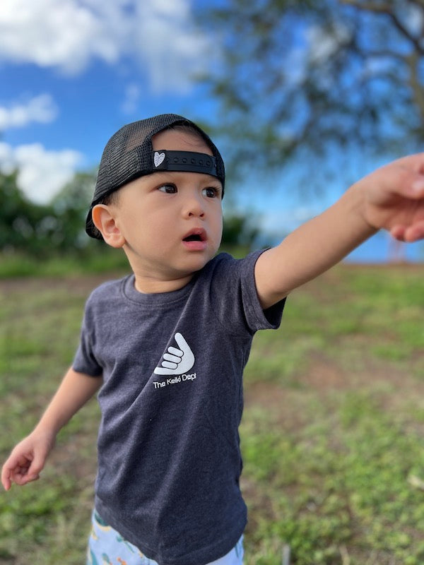 front of a hui hou gotta go tshirt. shows a shaka with the words "the keiki dept" below