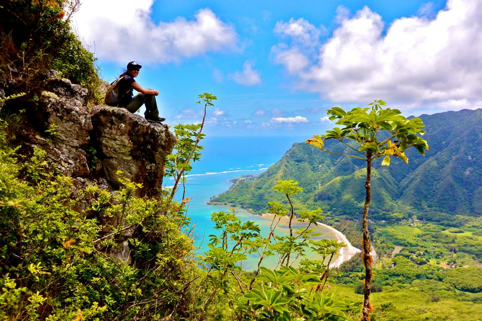 woman sitting on a rock on a hike in hawaii